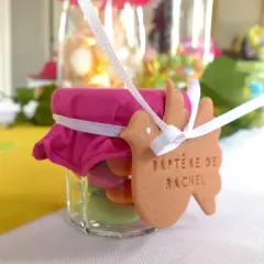 Un petit pot de dragées colorées pour le baptême de Rachel. Combien de dragées pour 30 personnes ? Environ 10 par invité.