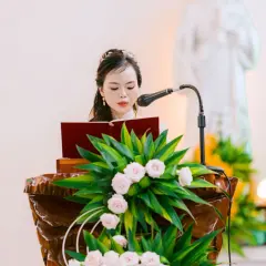 Une femme lit un texte devant un pupitre fleuri. La question "faut il etre baptisé pour etre temoin a l'eglise" résonne.
