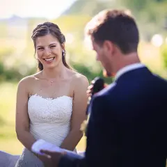 La mariée rayonne, écoutant attentivement le discours mariage meilleure amie. Un moment tendre et joyeux en plein air.