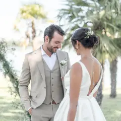 Un couple de mariés, plein de tendresse, sous les palmiers. Une scène de shooting inspiration mariage, empreinte de bonheur et d'élégance.