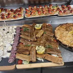 Un buffet départ retraite festif : mini-brochettes, roulés croustillants, fromages, charcuterie et une grande tarte salée.