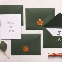 Ensemble d'invitations de mariage avec sceaux de cire dorés et une carte "Save the Date". Une idée élégante pour annoncer votre union.