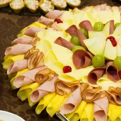 Plateau de charcuterie et fromage pour un repas baptême 30 personnes. Joliment décoré avec des fruits et des cerises confites.