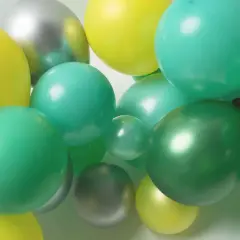 Grappe de ballons verts, jaunes et argentés. Idéal pour apprendre comment attacher des ballons en grappe pour une décoration festive.