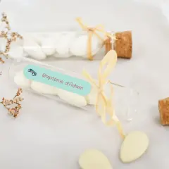 Des dragées pour créer une liste de baptême, dans des fioles décorées d'une petite voiture et du nom "Adam".
