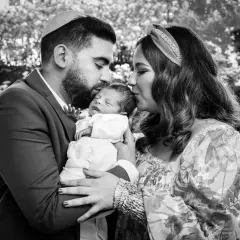Un couple juif célèbre la circoncision de leur bébé, entourés d'amour et de tendresse.