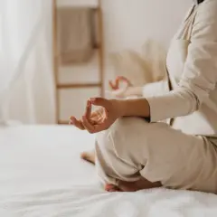 Une femme médite sur son lit, paisiblement installée pour bien commencer la fete 1er janvier.