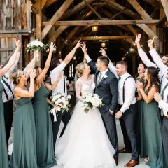La mariée et son cortège de demoiselles d'honneur célèbrent joyeusement leur mariage dans une grange rustique.