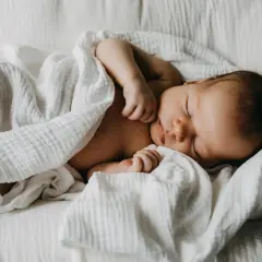 Un doux bébé endormi, parfait pour un texte félicitations naissance garçon. Un petit trésor emmailloté dans une couverture blanche.