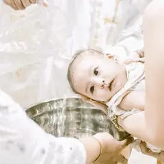 Bébé se fait baptiser sans catéchisme, l'eau bénite coule dans la cuve.