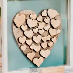 Livre d'or mariage coeur en bois, rempli de petits cœurs gravés de noms, un souvenir précieux des vœux échangés.