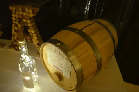 Urne mariage tonneau de vin, décorée de guirlandes lumineuses et de bouchons.