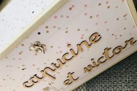 Boîte souvenir mariage personnalisée avec les prénoms "Capucine et Victor" en lettres dorées sur fond à pois.