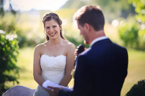 La mariée rayonne, écoutant attentivement le discours mariage meilleure amie. Un moment tendre et joyeux en plein air.