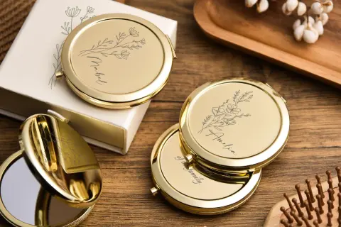 Un miroir de poche personnalisé, orné de délicates fleurs et d'un prénom, prêt à illuminer le quotidien.