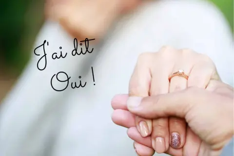 Un texte fiançailles original : "J'ai dit Oui !" sur une image de mains tenant un anneau de fiançailles.