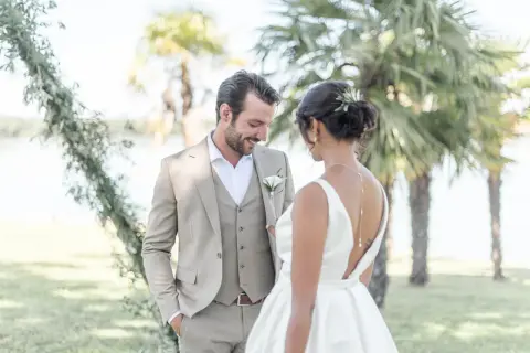 Un couple de mariés, plein de tendresse, sous les palmiers. Une scène de shooting inspiration mariage, empreinte de bonheur et d'élégance.