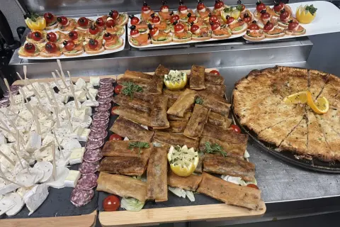 Un buffet départ retraite festif : mini-brochettes, roulés croustillants, fromages, charcuterie et une grande tarte salée.