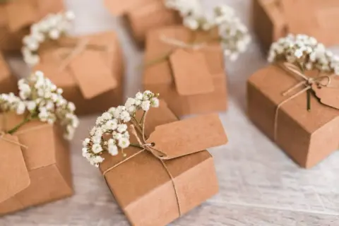 Petits pochons dragées à faire soi même, décorés de gypsophile et d'étiquettes kraft. Parfaits pour une touche personnalisée.