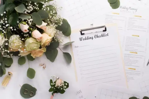 Un bouquet de roses, des alliances, un parfum et une liste de contrôle pour l'organisation mariage soi-même.