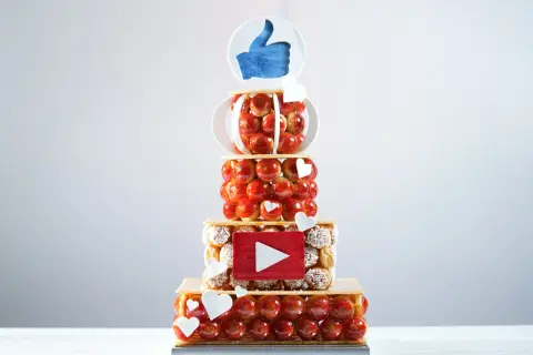 Pièce montée en choux, décorée d'un pouce levé et d'un logo YouTube. Peut-on faire une pièce montée en choux la veille ? Oui, pour un résultat aussi réussi !