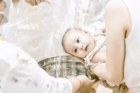 Bébé se fait baptiser sans catéchisme, l'eau bénite coule dans la cuve.