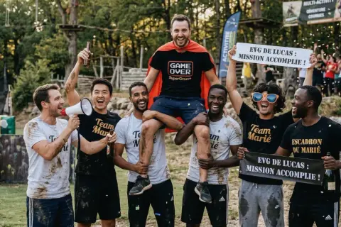 Des amis célèbrent la réussite d'un enterrement de vie de garçon. Le marié, en cape de super-héros, est porté par ses amis. Mission accomplie !