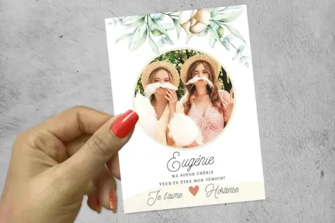Carte "texte demande témoin mariage originale" avec deux jeunes femmes portant des moustaches en barbe à papa. Eugénie demande à Hortense d'être sa témoin.