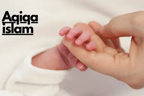 Main d'un nouveau-né tenant un doigt adulte. Le texte "Aqiqah Islam" est superposé, évoquant la tradition du mouton naissance islam.