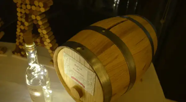 Urne mariage tonneau de vin, décorée de guirlandes lumineuses et de bouchons.