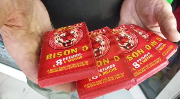 Des pétards "Bison O" sont tenus dans des mains. La question est : a-t-on le droit de faire péter des pétards ?