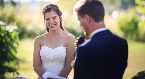 La mariée rayonne, écoutant attentivement le discours mariage meilleure amie. Un moment tendre et joyeux en plein air.