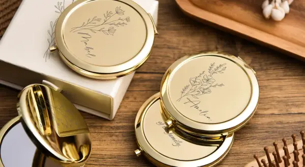 Un miroir de poche personnalisé, orné de délicates fleurs et d'un prénom, prêt à illuminer le quotidien.