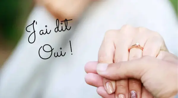 Un texte fiançailles original : "J'ai dit Oui !" sur une image de mains tenant un anneau de fiançailles.