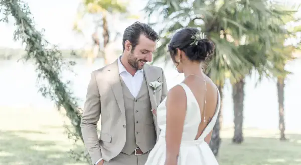 Un couple de mariés, plein de tendresse, sous les palmiers. Une scène de shooting inspiration mariage, empreinte de bonheur et d'élégance.