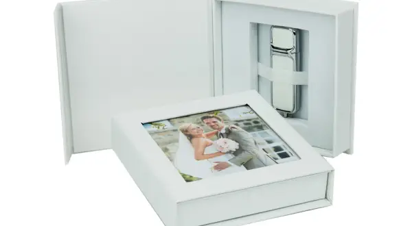 Boîte blanche avec une photo de mariage sur le couvercle et une clé usb personnalisée mariage à l'intérieur.
