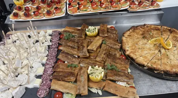 Un buffet départ retraite festif : mini-brochettes, roulés croustillants, fromages, charcuterie et une grande tarte salée.