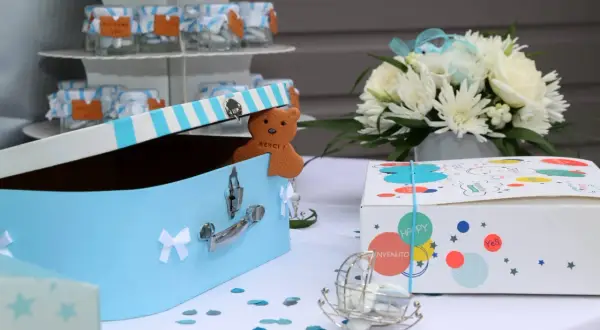 Une boîte à trésors bleue pour un baptême, avec un ours en biscuit "Merci !" et des petits pots de dragées. Une idée de gazette baptême à télécharger.