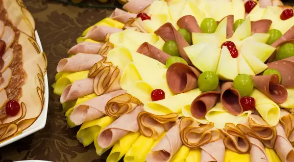 Plateau de charcuterie et fromage pour un repas baptême 30 personnes. Joliment décoré avec des fruits et des cerises confites.