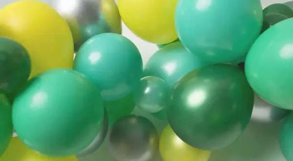 Grappe de ballons verts, jaunes et argentés. Idéal pour apprendre comment attacher des ballons en grappe pour une décoration festive.