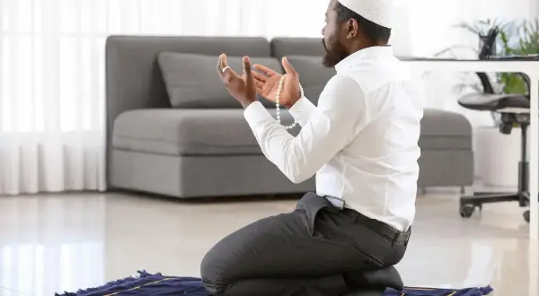 Homme en prière, tenant un chapelet, une invocation pour la circoncision dans l'islam.