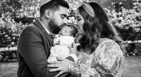 Un couple juif célèbre la circoncision de leur bébé, entourés d'amour et de tendresse.