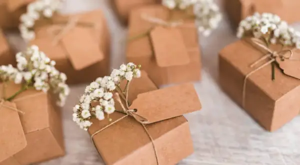 Petits pochons dragées à faire soi même, décorés de gypsophile et d'étiquettes kraft. Parfaits pour une touche personnalisée.