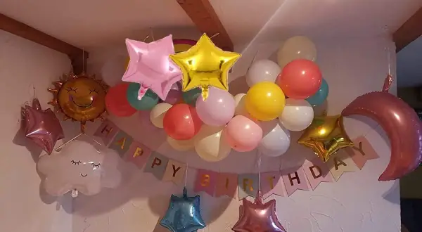 Ballons en étoile, lune, soleil et nuage flottent joyeusement, mais attention au danger de l'hélium pour les enfants.