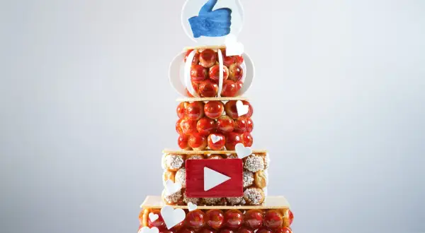 Pièce montée en choux, décorée d'un pouce levé et d'un logo YouTube. Peut-on faire une pièce montée en choux la veille ? Oui, pour un résultat aussi réussi !
