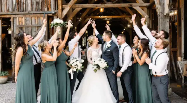 La mariée et son cortège de demoiselles d'honneur célèbrent joyeusement leur mariage dans une grange rustique.