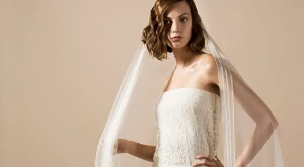 Une mariée porte une robe bustier en dentelle et un voile aérien, une création Delphine Manivet.