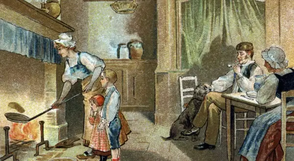 Une famille prépare des crêpes près du feu, une tradition qui rappelle qu'est-ce que la Chandeleur. Un chien attend patiemment.