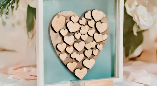 Livre d'or mariage coeur en bois, rempli de petits cœurs gravés de noms, un souvenir précieux des vœux échangés.