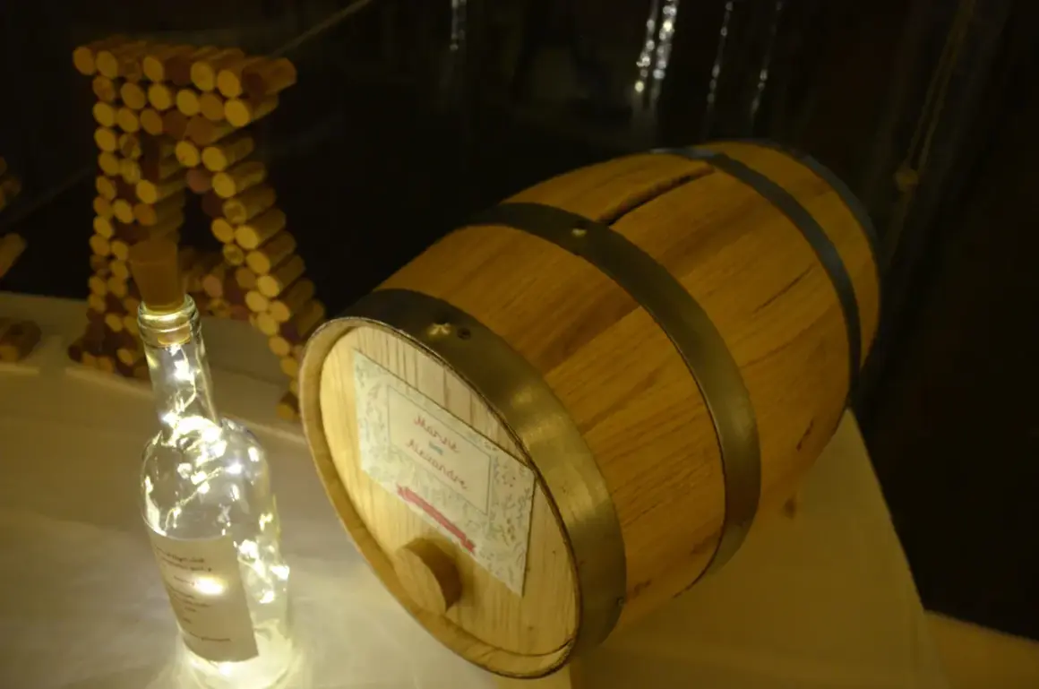 Urne mariage tonneau de vin, décorée de guirlandes lumineuses et de bouchons.